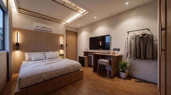 A modern bedroom with a bed, desk, TV, and a plant. - Restia Gimhae Jangyu (Gimhae)