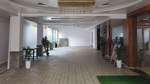 Amplio espacio interior con piso estampado, un candelabro central y plantas en macetas.