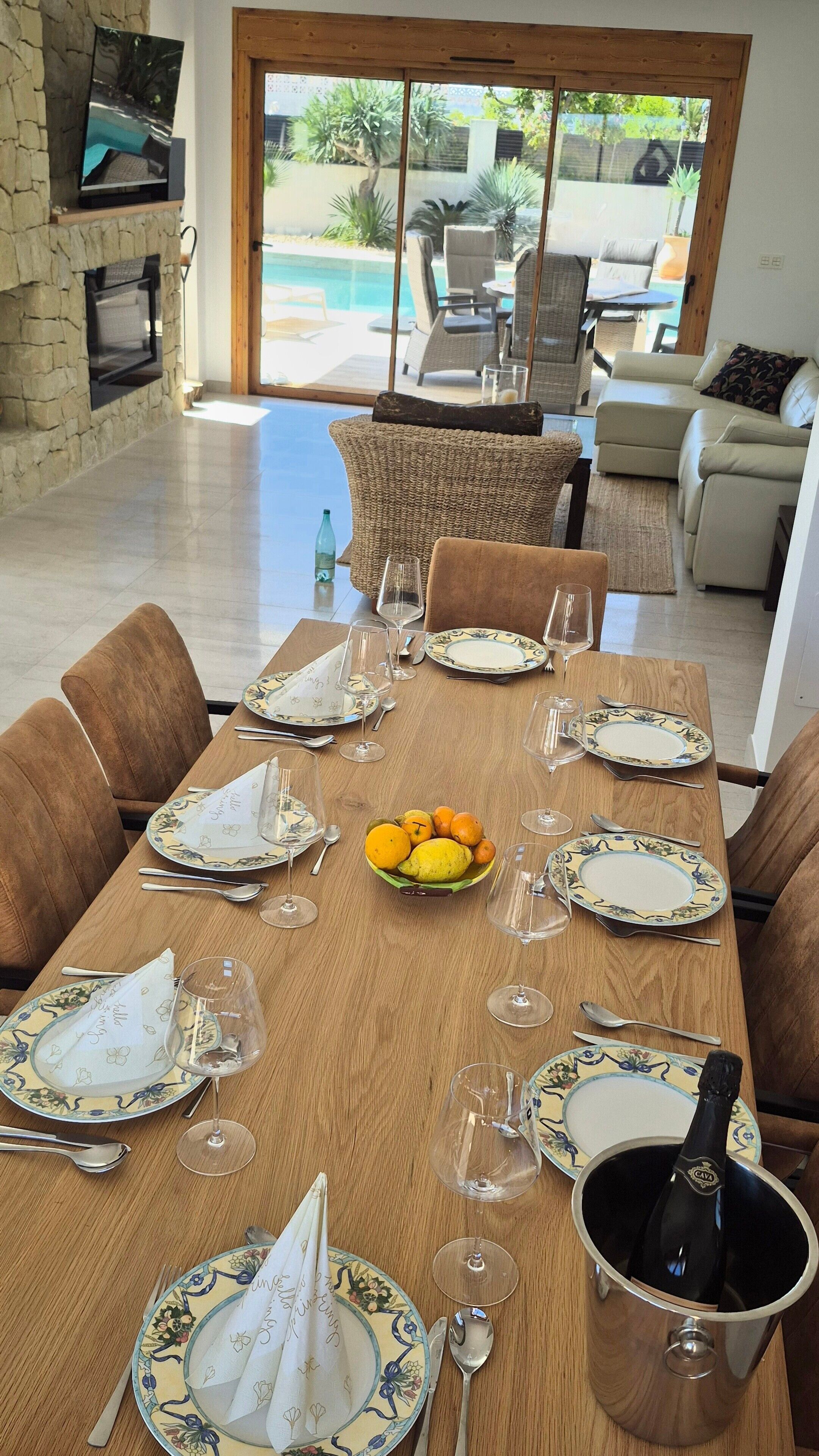 Un espace repas avec une table en bois dressée pour le repas, entourée de chaises.
