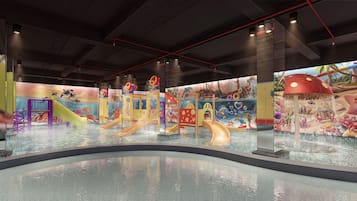 Zona de juegos acuáticos interior con toboganes y fuentes.