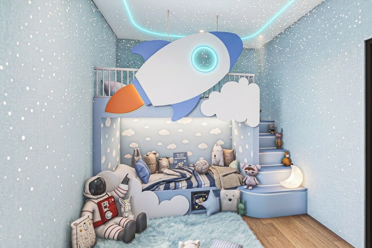 Un dormitorio infantil con literas, un adorno en forma de cohete en el techo y varios peluches.