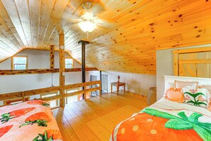 Ein Holzinnenraum mit einem Etagenbett, einer Treppe und einem Deckenventilator.
