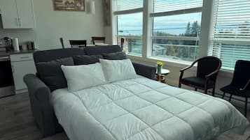 Une chambre moderne avec un lit, un bureau et une vue sur l’extérieur.