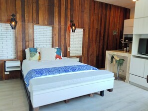 Ein Schlafzimmer mit einem Bett, Holzwandverkleidung, einer Ziegelwand, einem weißen Schrank und einem Fernseher.