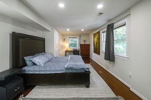 A bedroom with a bed, bedside tables, a dresser, a window with curtains, and a painting on the wall. - Gateway to DC, Waterfalls & More! McLean Apartment (McLean)