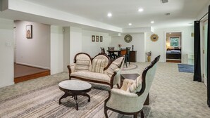 A spacious living room with a large sofa set, a coffee table, and a dining area in the background. - Gateway to DC, Waterfalls & More! McLean Apartment (McLean)
