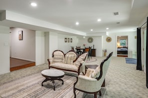 A spacious living room with a large sofa set, a coffee table, and a dining area in the background. - Gateway to DC, Waterfalls & More! McLean Apartment (McLean)