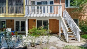 A two-story building with a balcony, a staircase, and a patio area with outdoor furniture. - Gateway to DC, Waterfalls & More! McLean Apartment (McLean)