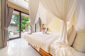 A bedroom with a large bed, a canopy, and a view of a garden through a glass door. - Serene 2BR Retreat w Pool & Lounge, Canggu's Heart (Kuta Utara)