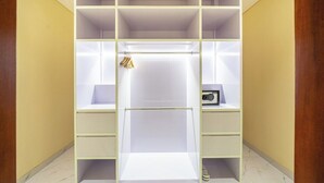 A walk-in closet with multiple shelves and drawers, a hanging rod, and a small shelf with a radio. - Serene 2BR Retreat w Pool & Lounge, Canggu's Heart (Kuta Utara)
