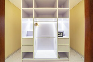 A walk-in closet with multiple shelves and drawers, a hanging rod, and a small shelf with a radio. - Serene 2BR Retreat w Pool & Lounge, Canggu's Heart (Kuta Utara)