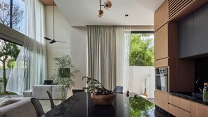 A modern dining area with a glass table, chairs, and a decorative bowl. - Chic 3BR Townhouse • Beach Nearby • Pool • Umalas (Kuta Utara)