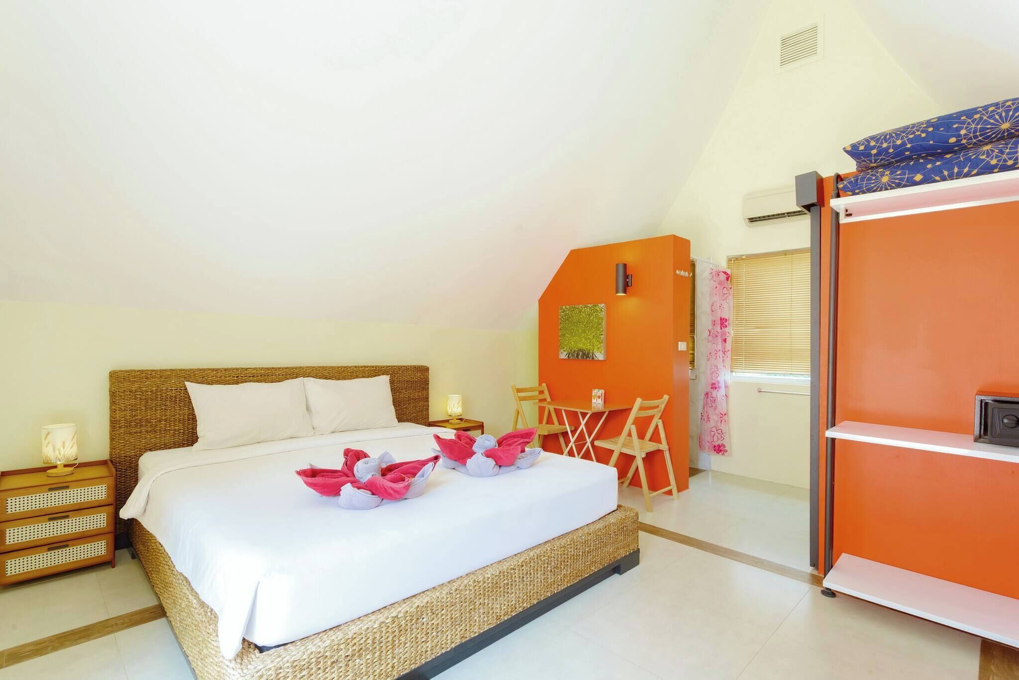 Une chambre à coucher avec un lit, une chaise, une petite table et une armoire.