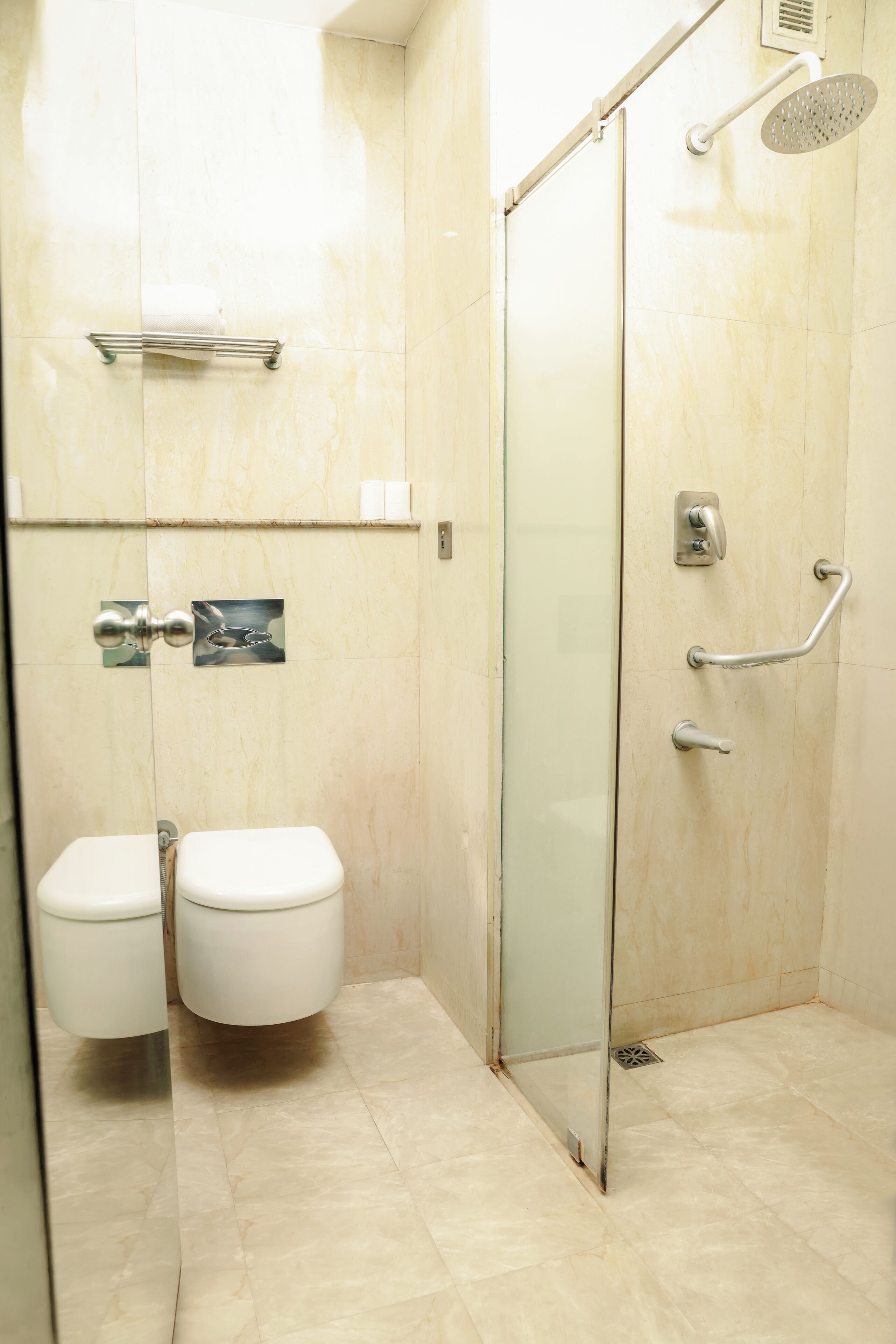 Un baño con cabina de ducha de vidrio, inodoro y bidé.