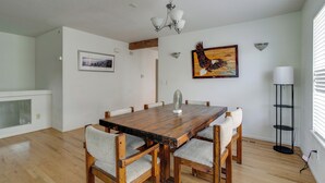 A dining room with a wooden table, six chairs, a chandelier, and artwork on the walls. - Fenced Yard! Family Home on Golf Course in Denver (Denver)