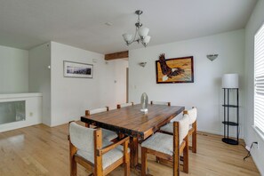 Ein Esszimmer mit Holztisch, sechs Stühlen, einer Kandelaber und Kunstwerken an den Wänden.