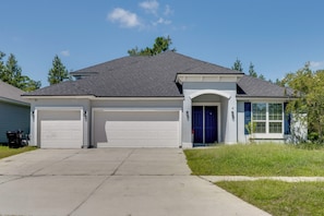 A two-story house with a garage, a front porch, and a small front yard. - Orange Park 'The Gathering House' w/ Pool Access (Orange Park)
