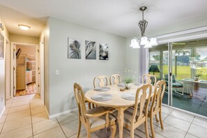 A dining area with a round table, six chairs, and a potted plant. - 'Fifth Gold Tee' Fairway Views, Lanai & Golf Cart! (Lady Lake)
