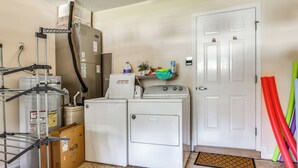 Une buanderie équipée d’un lave-linge, d’un sèche-linge et de piles de cartons.