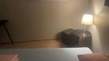 Una habitación con una cama, una lámpara y una silla.