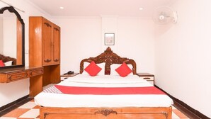 Un dormitorio con cama de madera, armario, mesita de noche y espejo.