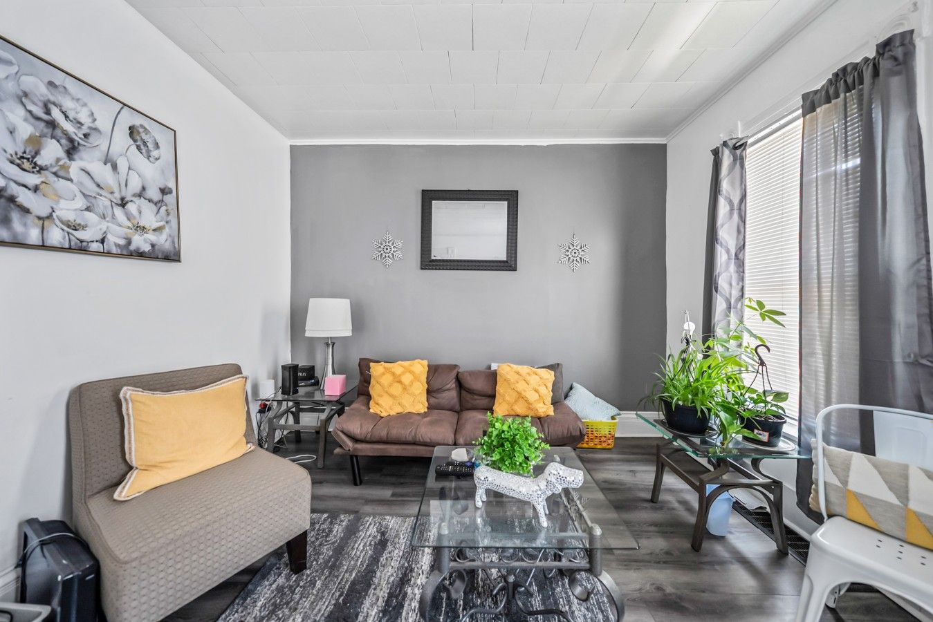 Un salon moderne avec un canapé, une table basse et des coussins décoratifs.