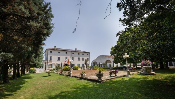 Ein Innenhof mit einem Gebäude, einer Fontäne und Pflanzkübeln.