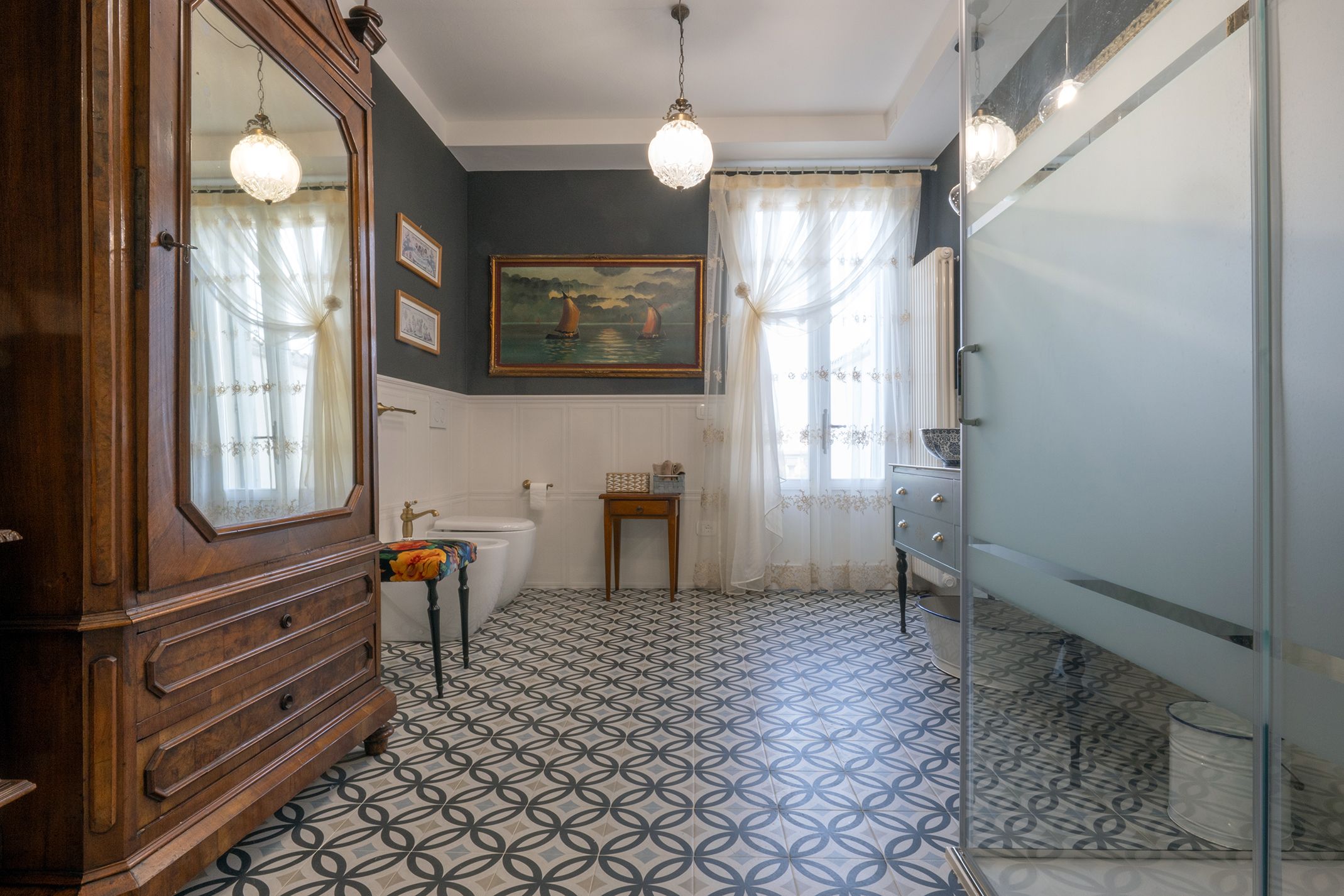 Un baño con un mueble de madera, un lavabo, un inodoro, una bañera y un espejo.