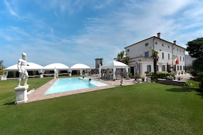 A pool area with a statue, a large building with multiple windows, and a well-maintained lawn. - HISTORIC COUNTRY ESTATE — LUXURY AND RELAXATION — SWIMMING POOL — HOT TUB — PET-FRIENDLY (Veneto)