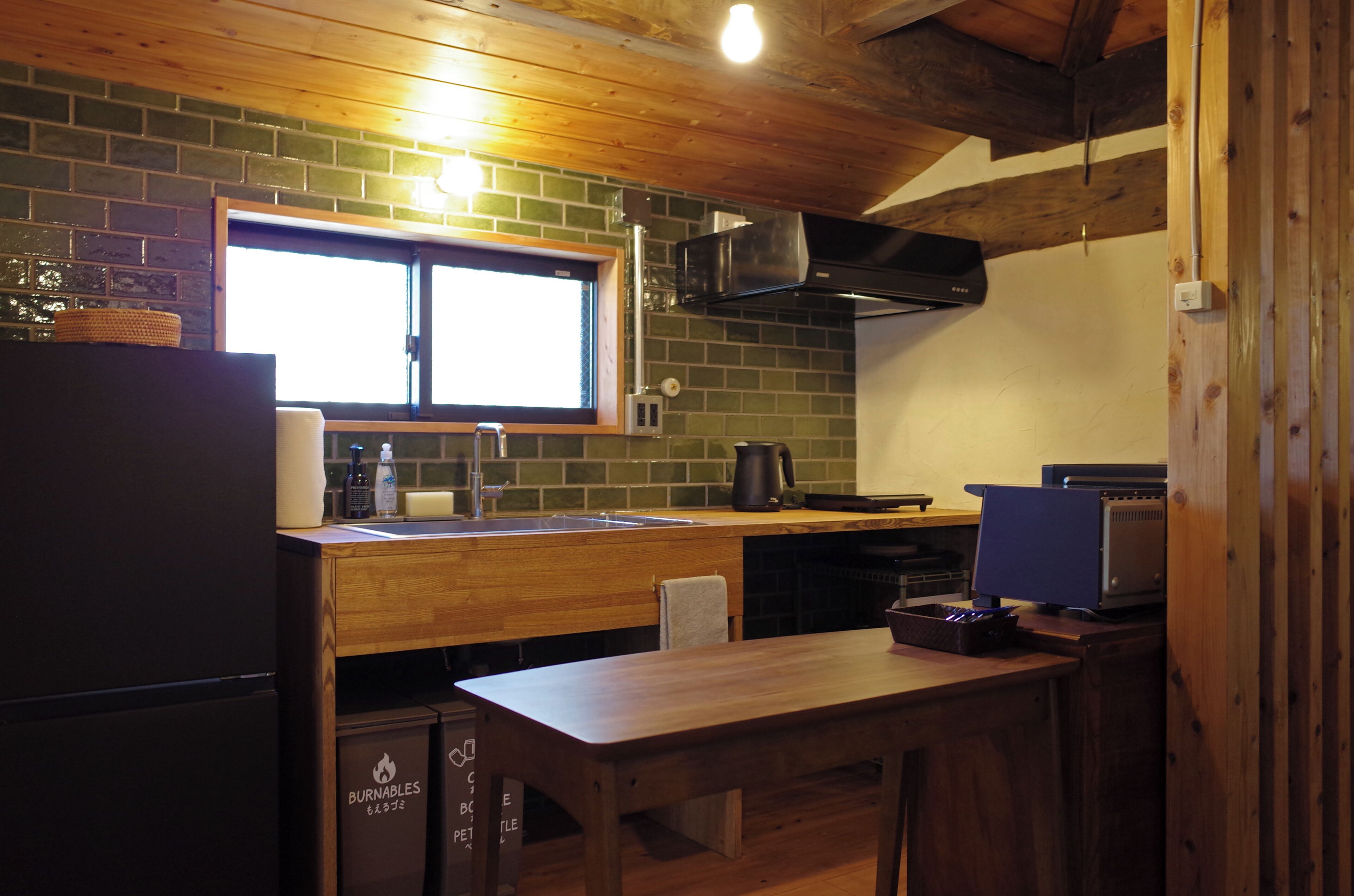 A compact kitchen with a wooden countertop, a sink, and a window above it.