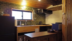 A compact kitchen with a wooden countertop, a sink, and a window above it.