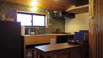 A compact kitchen with a wooden countertop, a sink, and a window above it.