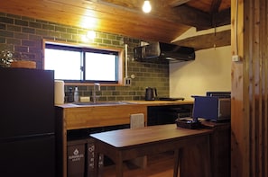 A compact kitchen with a wooden countertop, a sink, and a window above it.