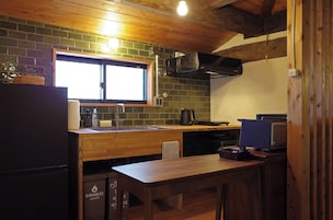 Uma cozinha compacta com bancada de madeira, pia e janela acima.