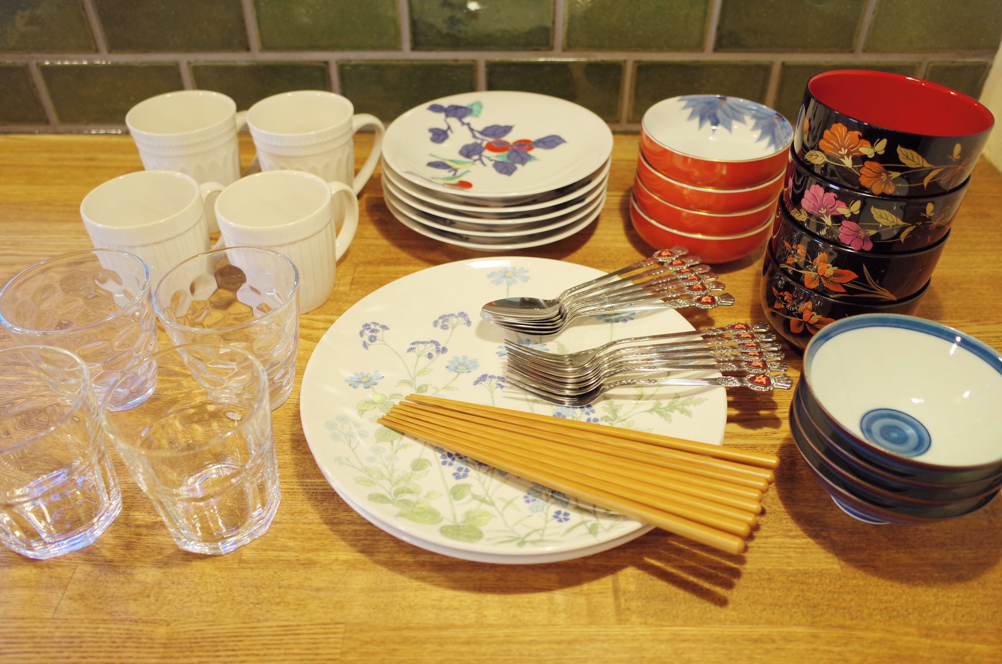 A table with various kitchenware items including plates, cups, and utensils.