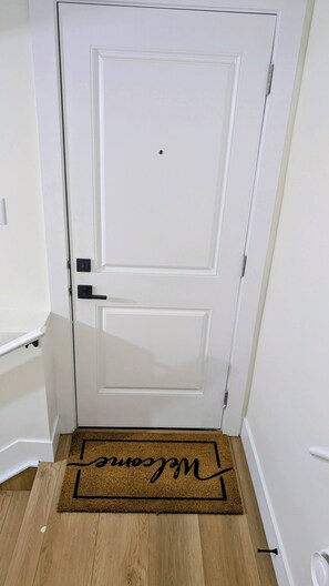 A white door with a doormat that reads 'Welcome.'