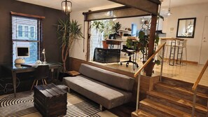 A modern living space with a sofa, desk, and staircase. - Large urban apartment with steam sauna 1 (Montreal)