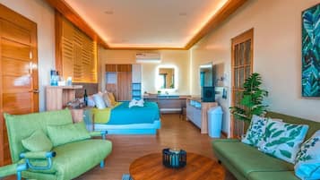 A modern hotel room with a bed, sofa, and a small kitchen area.