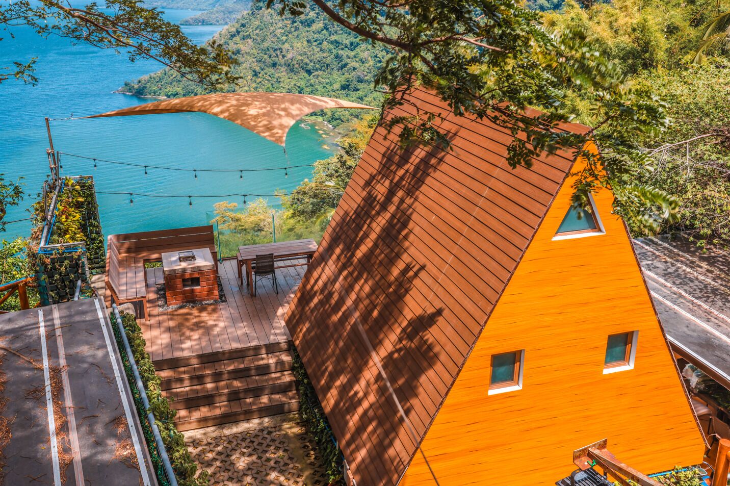 A modern house with a sloped roof, a deck, and a view of a lake.