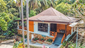 A two-story building with a stone facade, wooden exterior, and a tiled roof. - Noni's Resort (Alitagtag)