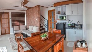 Un espacio moderno para vivir con mesa de comedor de madera, sofá y área de cocina.