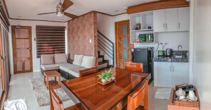 Un espacio moderno para vivir con mesa de comedor de madera, sofá y área de cocina.