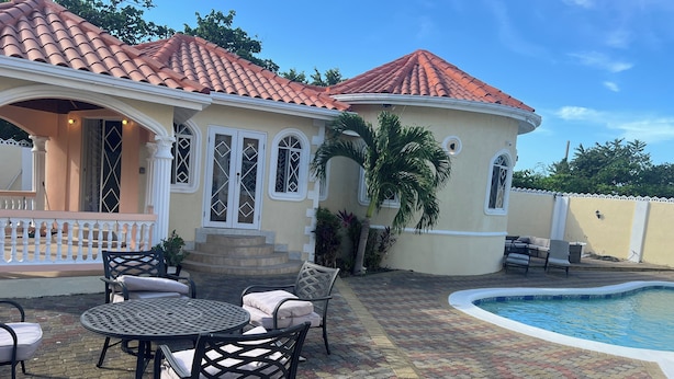 A house with a tiled roof, a pool, and outdoor furniture. - Plantation Villa with Pool-5-Min Walk to Plantation Cove, near by beach access. (Plantation Village)