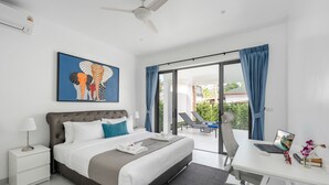 A modern hotel room with a bed, a desk with a laptop, a balcony with chairs, and a large window with curtains. - Buddha Bliss Luxury Villa (Tambon Ko Pha-Ngan)