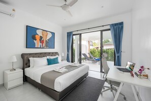 A modern hotel room with a bed, a desk with a laptop, a balcony with chairs, and a large window with curtains. - Buddha Bliss Luxury Villa (Tambon Ko Pha-Ngan)