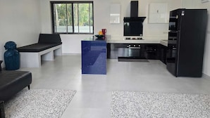 A modern kitchen with a central island, built-in appliances, and a large window providing natural light. - Buddha Bliss Luxury Villa (Tambon Ko Pha-Ngan)