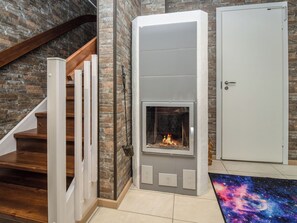 A modern interior with a fireplace, a staircase, and a door. - Tuiskukuru b by Interhome (Inari)
