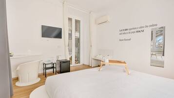 Une chambre d’hôtel moderne équipée d’un lit, d’un bureau, d’une chaise, d’une télévision et d’une fenêtre donnant sur un paysage agréable.