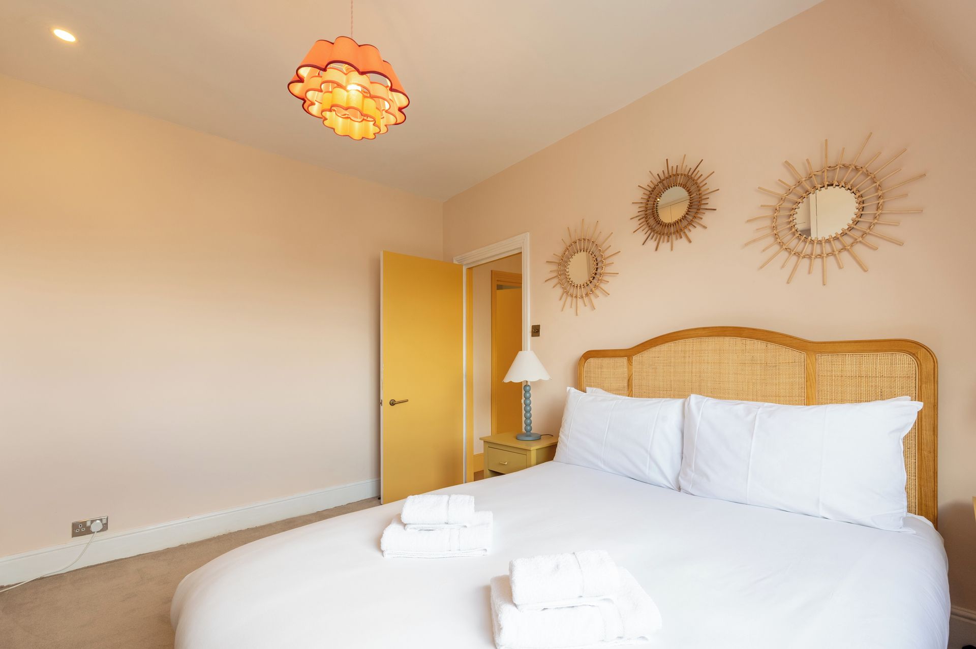 Ein Hotelzimmer mit einem Bett, einer Lampe und dekorativen Wandspiegeln.