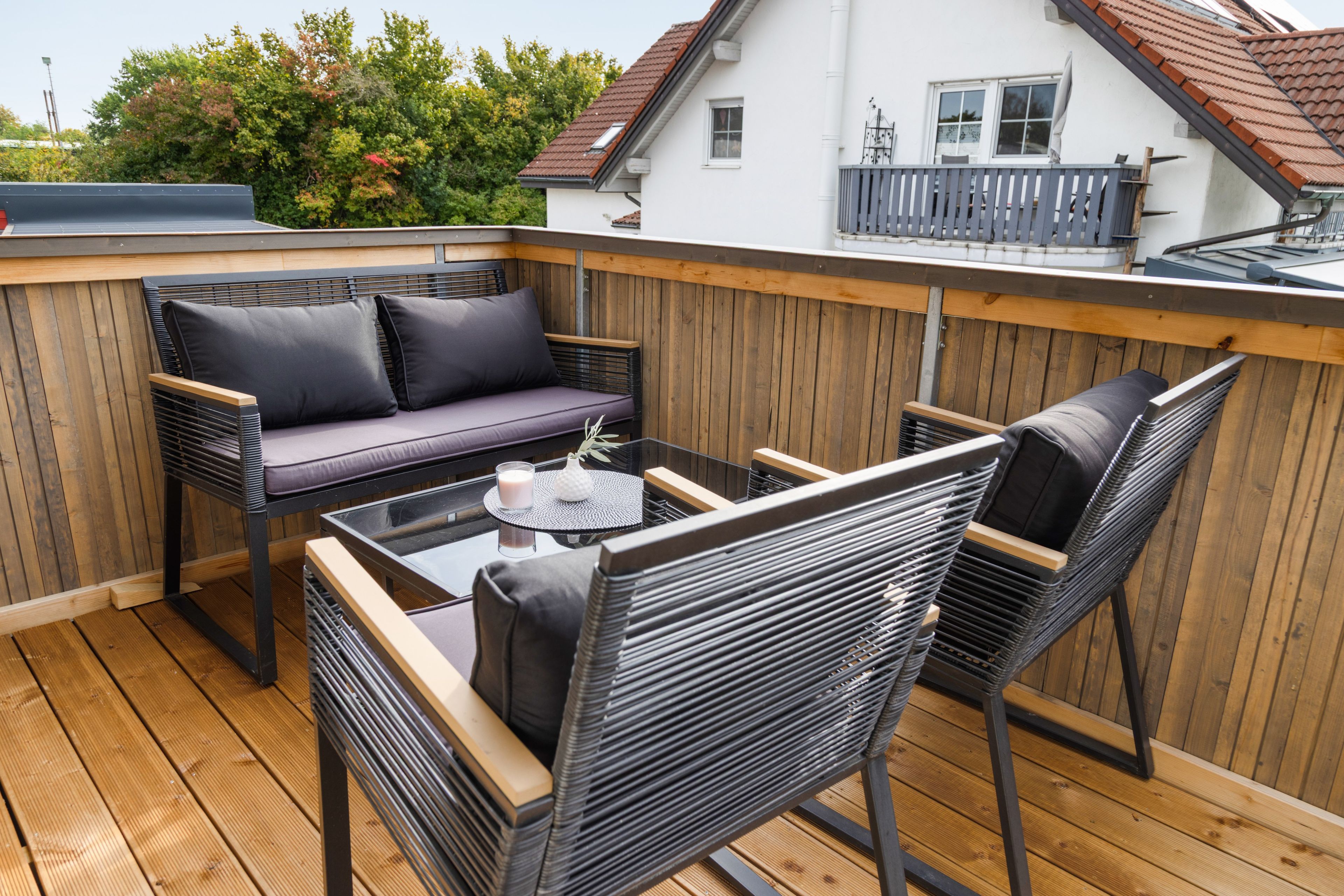 Eine Terrasse mit einer Couch, Stühlen und einem Tisch.